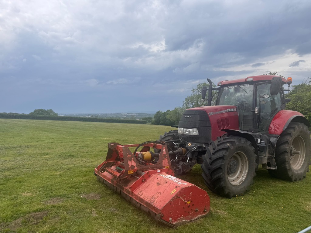 Tractor with a mower attachment in a grass field