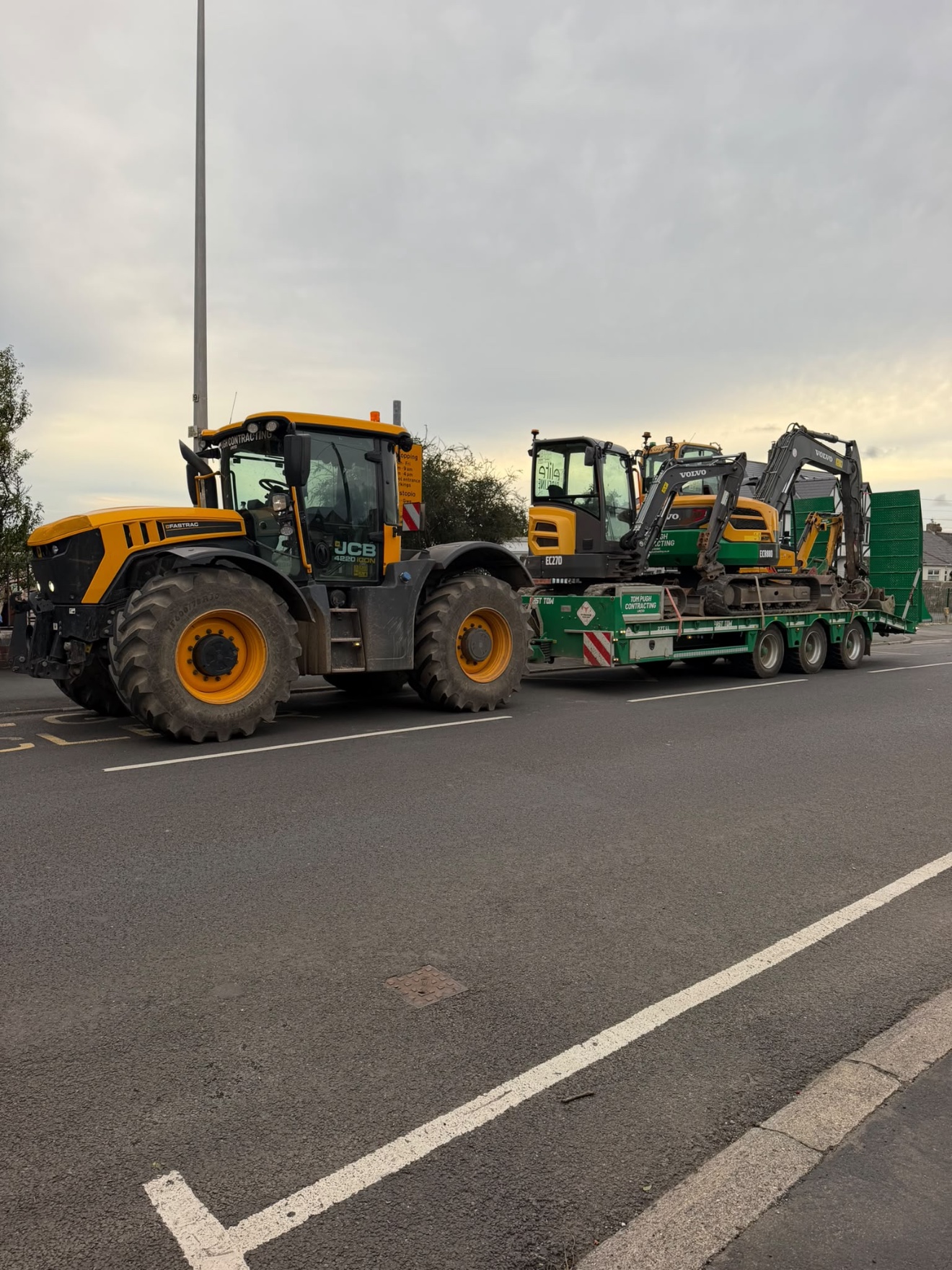 Tractor transporting excavators on a low-loader