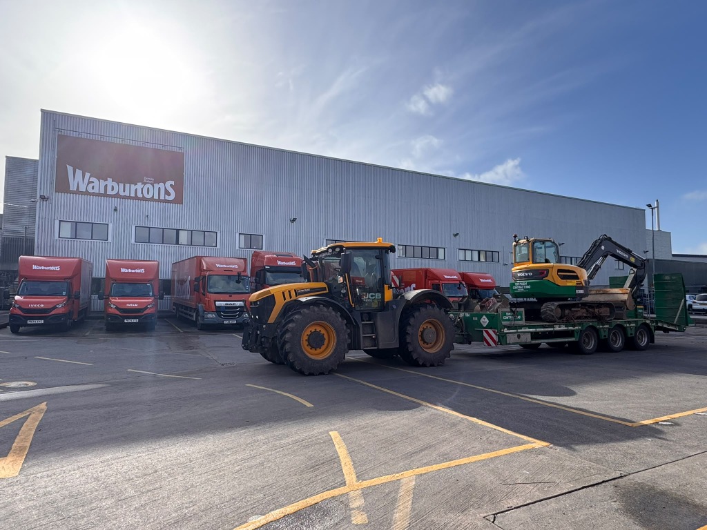 Tractor delivering an excavator on a low-loader