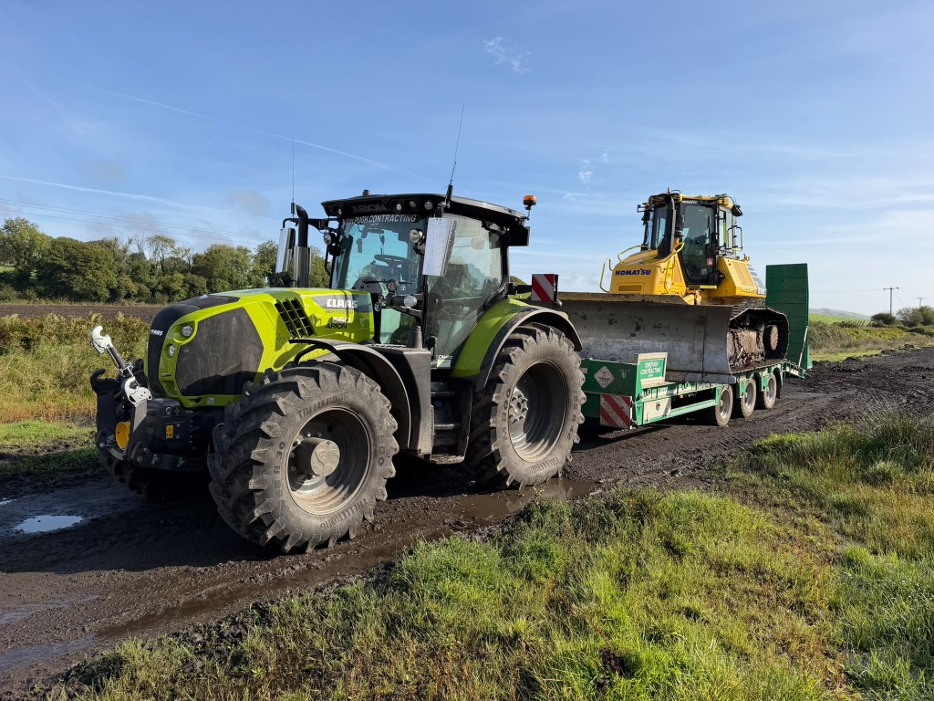 Tractor transporting a bulldozer on a low-loader