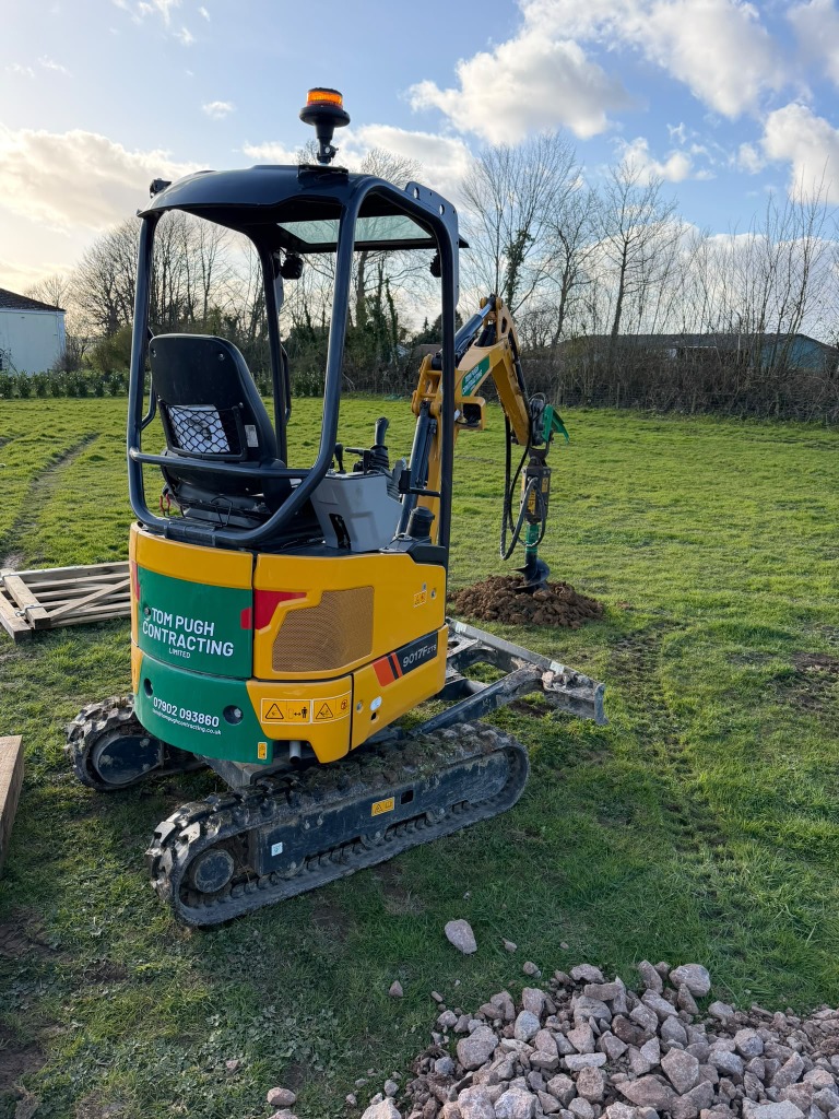 Mini excavator with an auger attachment
