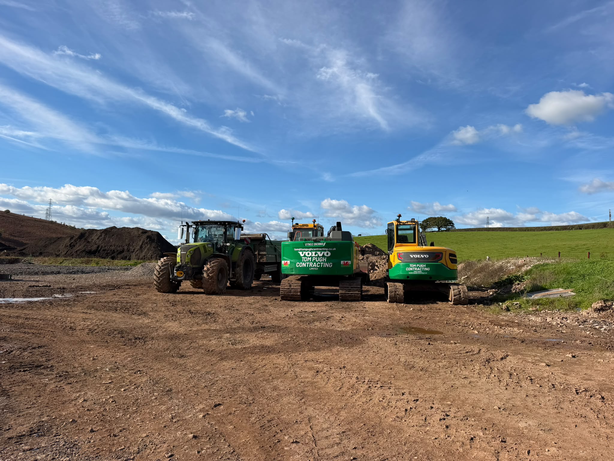 Tom Pugh Contracting tractor and two Volvo excavators on a countryside earthworks site
