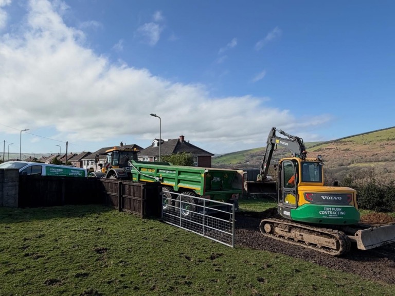 Excavator and tractor with a tipping trailer on site